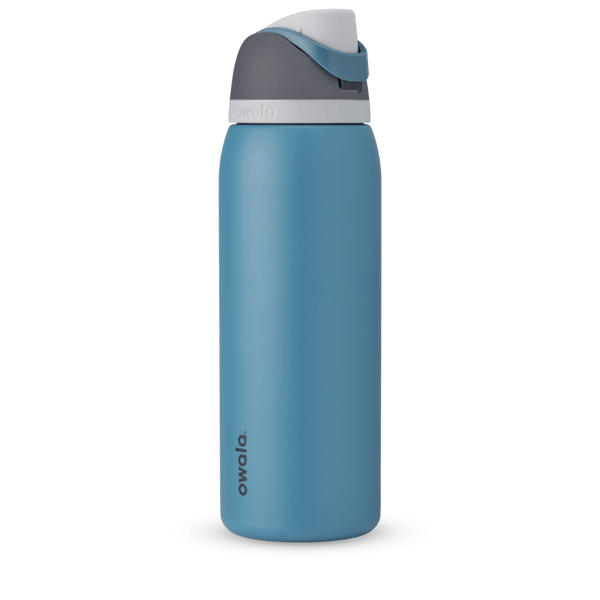 FreeSip 40oz in Blue Oasis, denim blue body with matching blue carry loop, dark gray flip cap, and white accent band