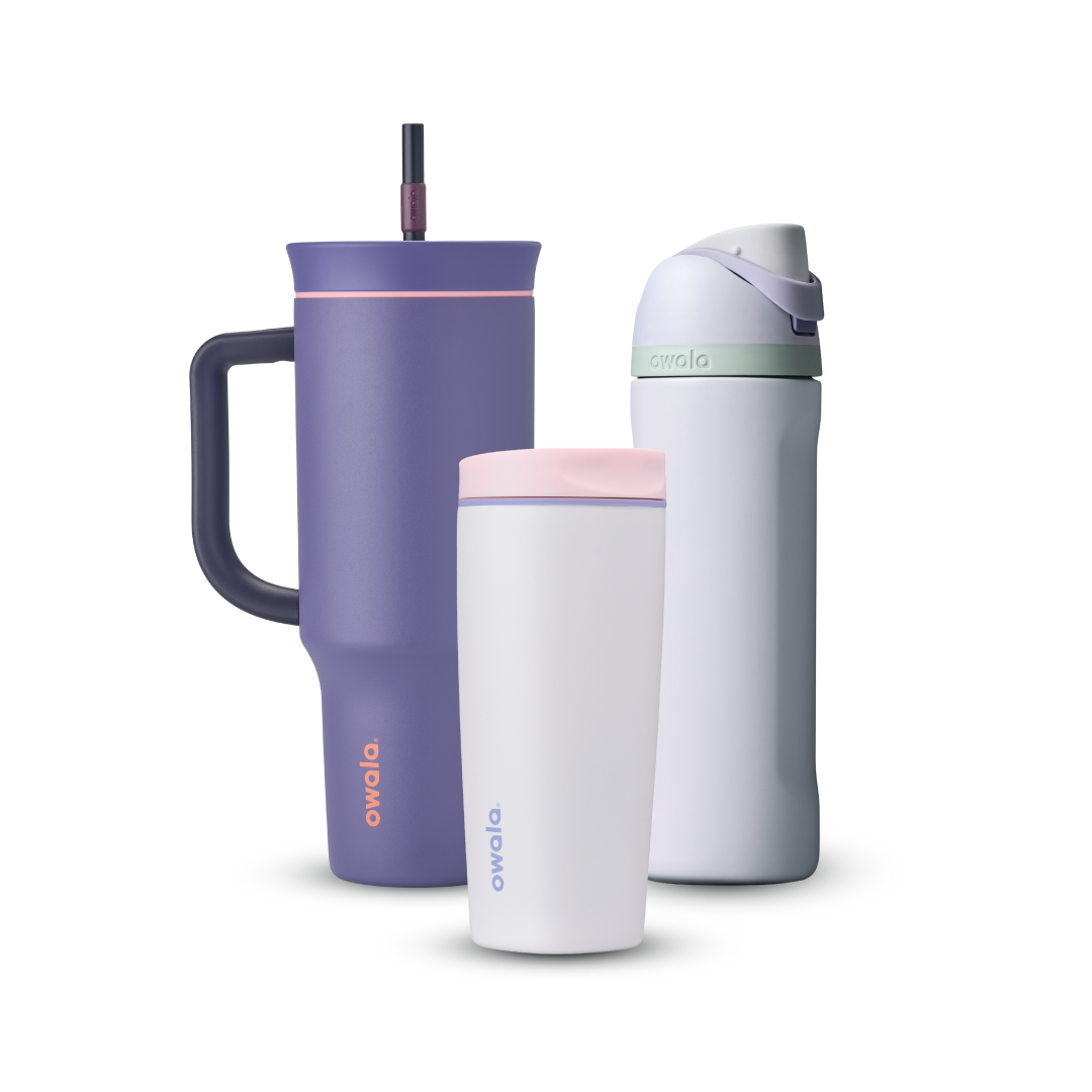 Owala All Day Bundle showing three bottles — a deep purple 40oz Tumbler with side handle, peach pink accent ring, and dark purple straw, a small white insulated cup with pink accent ring, and a white FreeSip with mint green accent band, lavender flip cap, and matching lavender carry loop Main image