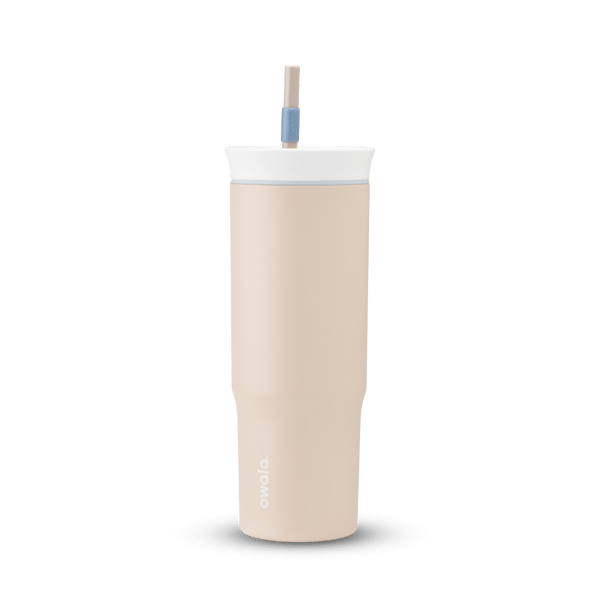 24oz Tumbler in Dune Drifter; matte sand-beige insulated tumbler with white lid, light gray accent ring, and tan straw with dusty blue grip, Owala wordmark on front